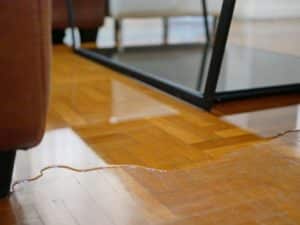 close-up-of-water-flooding-on-living-room-parquet-floor-in-a-house-water-damage-caused-by-water-leakage
