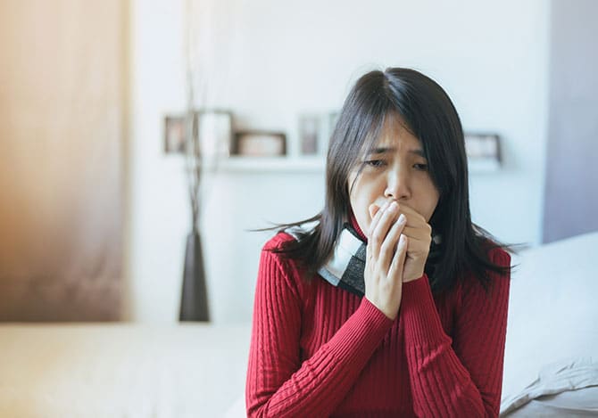 Woman suffering from indoor smoke and is coughing