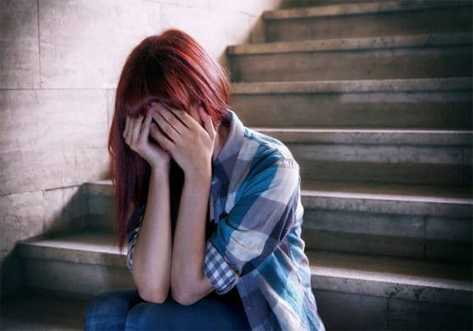 Woman depressed on the stairs of her basement